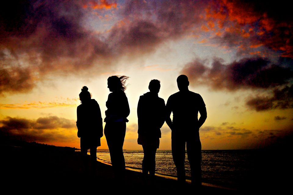 Silhouettes of a group of people at sunset