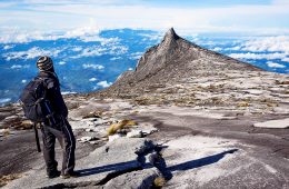 A man standing at the top of mount kinabalu