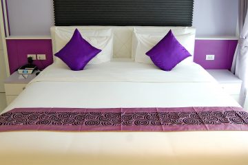 Double bed with two purple cushions