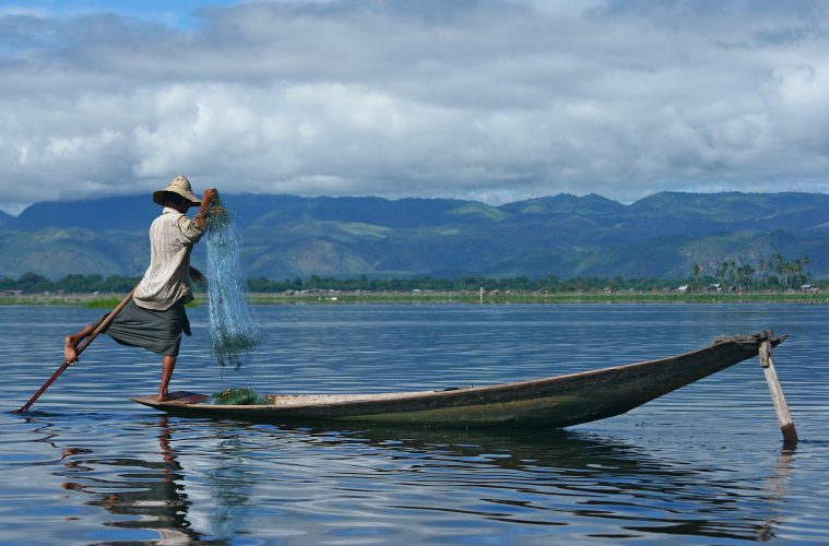 A man fishing off a canoe