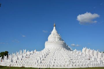 white temple with golden stupa against blue sky in Myanmar