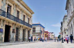 large street in oaxaca town center surrounded by buildings
