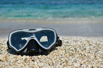 Black and white freediving mask on the sand